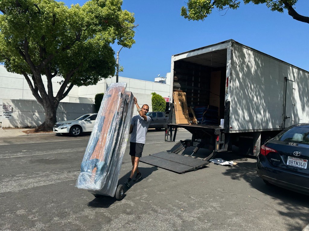 Wooden furniture shrink-wrapped and moved on a hand truck