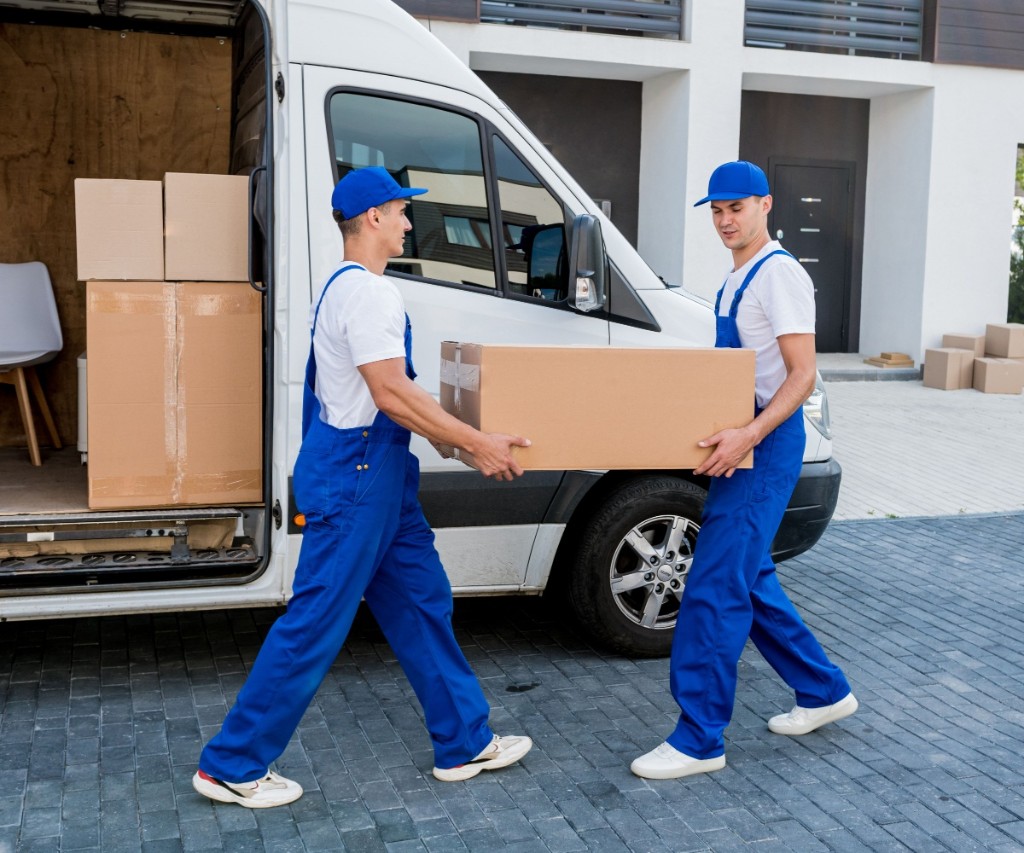 Two movers carrying a box from a cargo van
